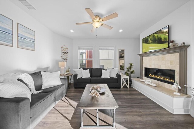 living area with ceiling fan, recessed lighting, a tile fireplace, and wood finished floors