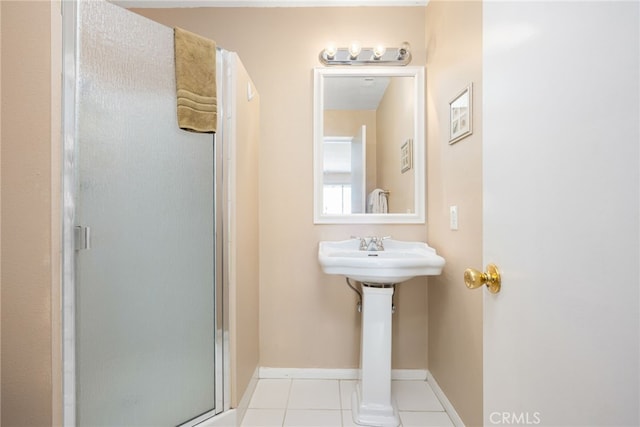 bathroom featuring tile patterned floors, a shower stall, and baseboards