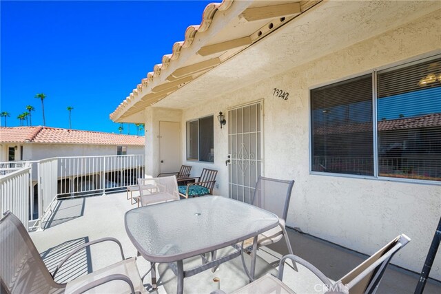 view of patio / terrace with a balcony and outdoor dining space