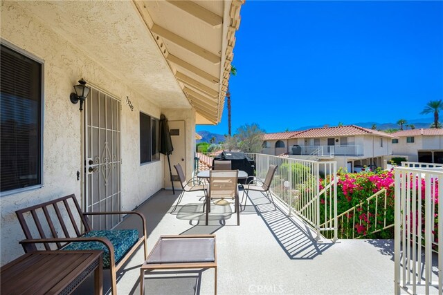view of patio featuring a balcony, outdoor dining area, a residential view, and area for grilling