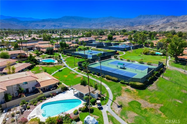 aerial view of residential area with a pool area and a mountain backdrop