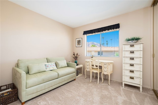 living area featuring light colored carpet and baseboards