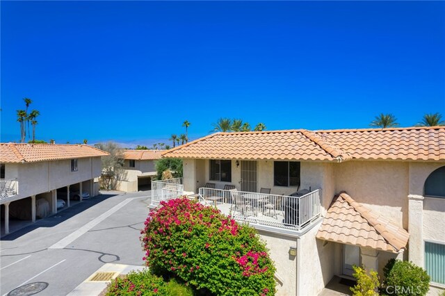 view of front of property with a tiled roof, stucco siding, and covered parking