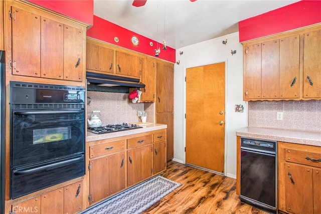 217 Syllmar Cir, Calimesa, CA 92320 - kitchen featuring black oven, a warming drawer, gas stovetop, wood finished floors, and decorative backsplash