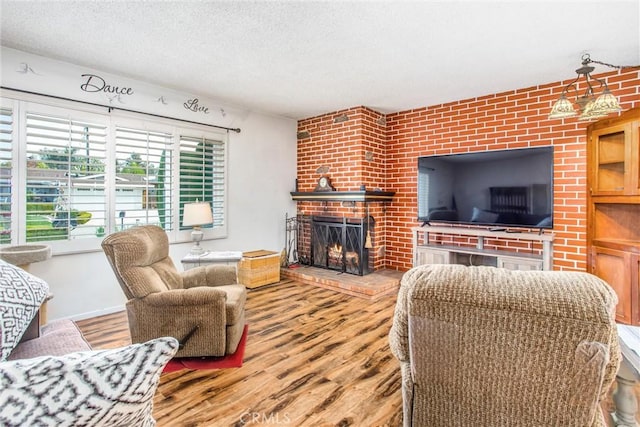 217 Syllmar Cir, Calimesa, CA 92320 - living area featuring a brick fireplace, wood finished floors, and a textured ceiling