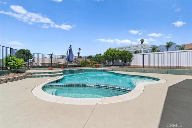 view of swimming pool featuring a fenced backyard and a pool with connected hot tub