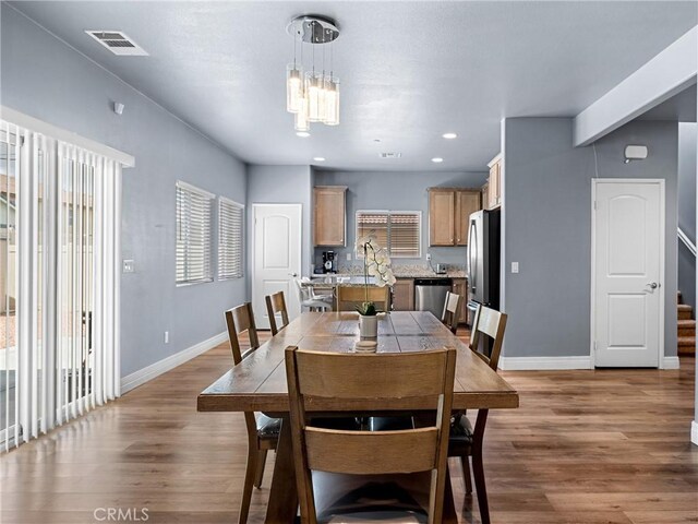 10630 Appaloosa Ave, Hesperia, CA 92345 - dining area featuring baseboards, wood finished floors, stairs, a chandelier, and recessed lighting