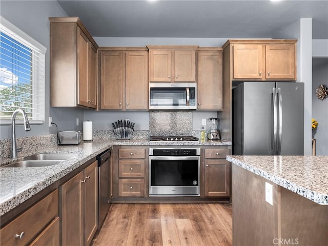 10630 Appaloosa Ave, Hesperia, CA 92345 - kitchen with stainless steel appliances, a sink, wood finished floors, and light stone counters