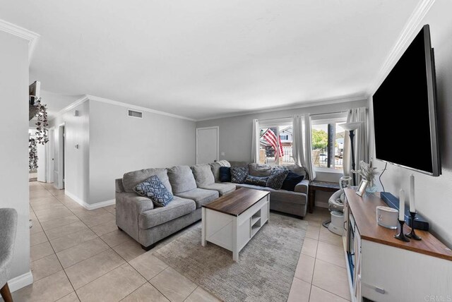living room featuring ornamental molding, light tile patterned floors, and baseboards