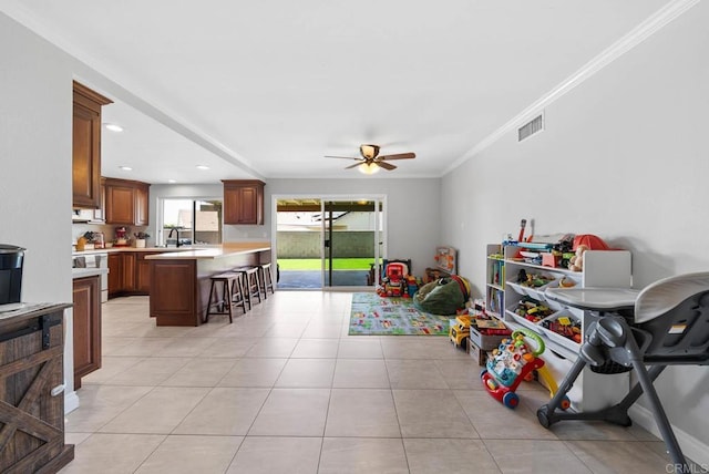rec room with ceiling fan, light tile patterned floors, ornamental molding, and recessed lighting