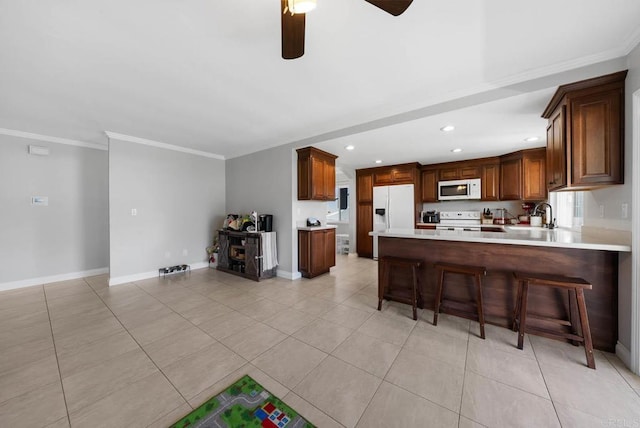 kitchen featuring white appliances, light countertops, recessed lighting, a ceiling fan, and crown molding