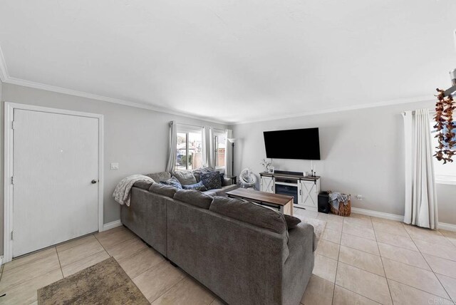 living area featuring light tile patterned floors, ornamental molding, and baseboards