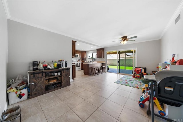 recreation room featuring crown molding, light tile patterned flooring, ceiling fan, and a sink