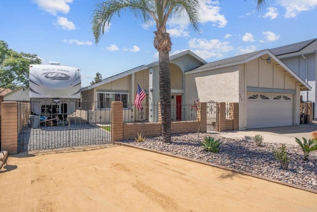 view of front facade featuring board and batten siding, concrete driveway, a garage, a fenced front yard, and a gate