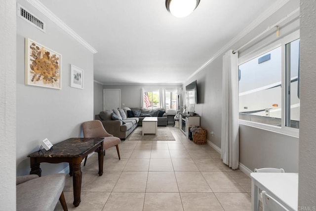 living area featuring crown molding, light tile patterned floors, and baseboards