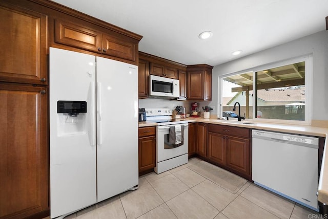 kitchen with white appliances, a sink, light countertops, light tile patterned floors, and recessed lighting