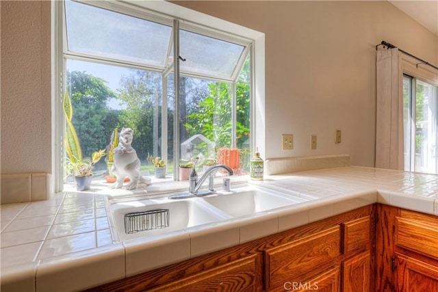 1918 Potter Rd, Chico, CA 95928 - kitchen with tile counters, brown cabinets, and a sink