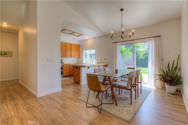1918 Potter Rd, Chico, CA 95928 - dining space featuring light wood-style floors, a chandelier, lofted ceiling, and baseboards