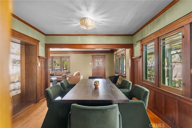 1156 E Howard St, Pasadena, CA 91104 - dining room featuring light wood finished floors, crown molding, wood walls, and a wainscoted wall