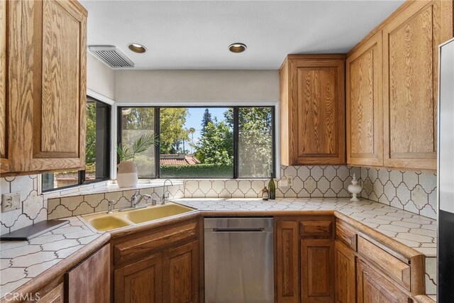 1156 E Howard St, Pasadena, CA 91104 - kitchen featuring dishwasher, tasteful backsplash, a sink, tile counters, and brown cabinetry