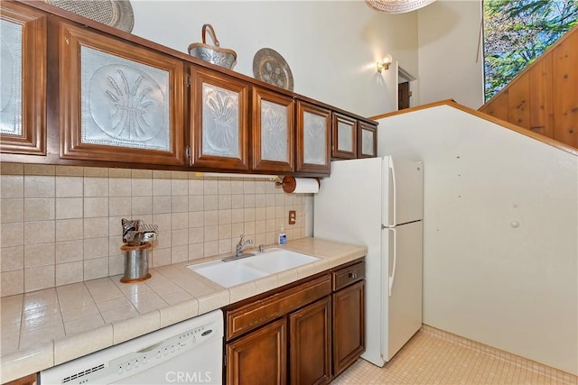27657 Peninsula Dr, Lake Arrowhead, CA 92352 - kitchen featuring a sink, tile countertops, white appliances, tasteful backsplash, and glass insert cabinets