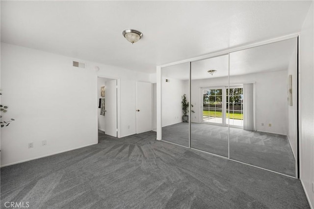 unfurnished bedroom featuring carpet flooring, access to outside, and a closet