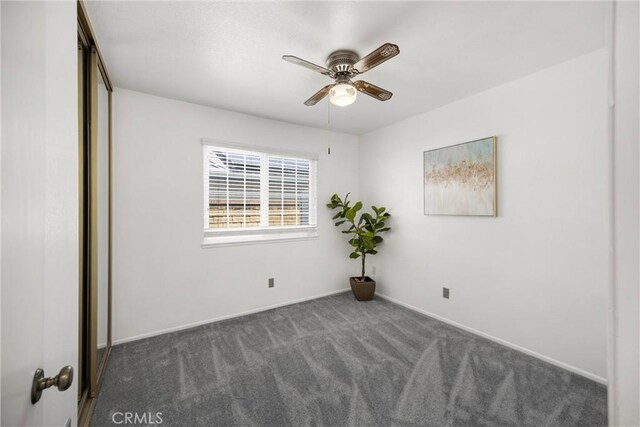 spare room with carpet floors, a ceiling fan, and baseboards