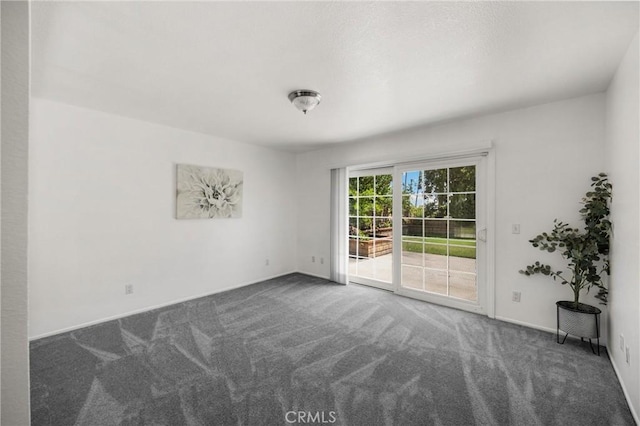 carpeted empty room featuring baseboards