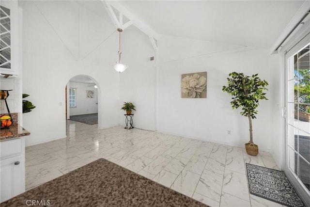 hall with arched walkways, marble finish flooring, and lofted ceiling