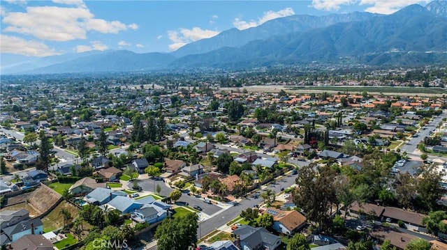 aerial view of property's location with a mountainous background and nearby suburban area