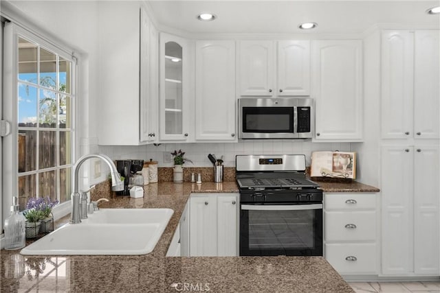 kitchen featuring stainless steel appliances, a sink, white cabinets, and recessed lighting