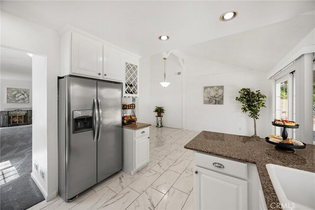 kitchen featuring stainless steel refrigerator with ice dispenser, white cabinets, a sink, light marble finish flooring, and recessed lighting