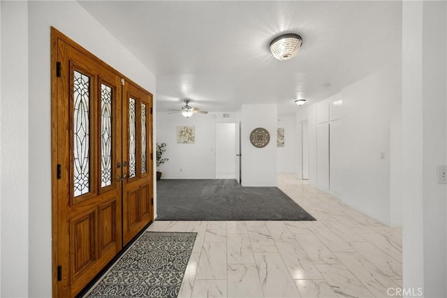 entryway featuring light marble finish floors and a ceiling fan