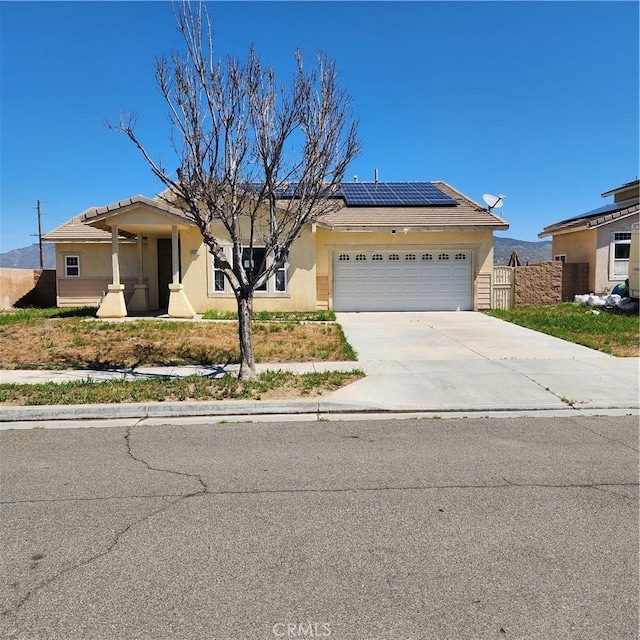 4542 Kalpesh Ct, Hemet, CA 92544 - view of front of home featuring an attached garage, solar panels, stucco siding, driveway, and fence