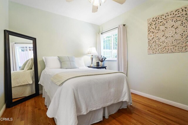 bedroom with baseboards, wood finished floors, and ceiling fan