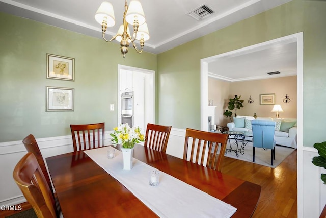 dining area with a chandelier and wood finished floors