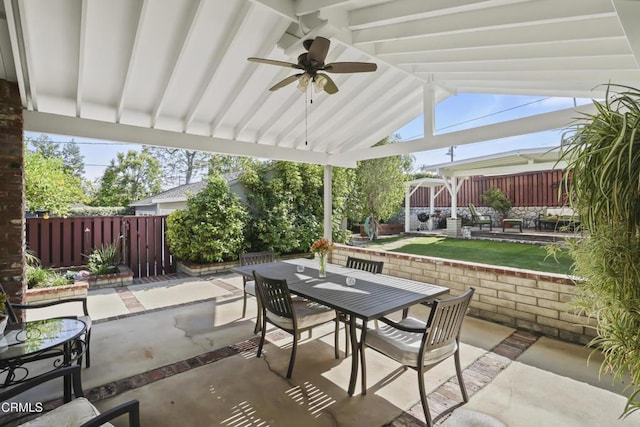view of patio featuring outdoor dining space, a fenced backyard, and a ceiling fan