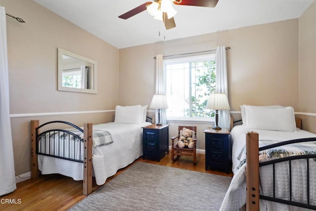 bedroom with wood finished floors, baseboards, and a ceiling fan