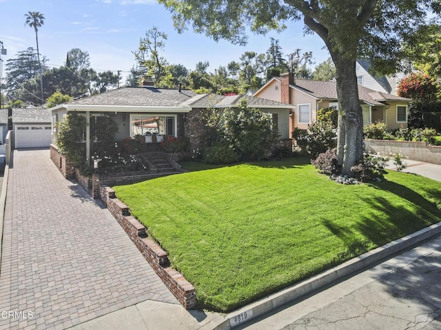 ranch-style home featuring a front lawn and an outdoor structure