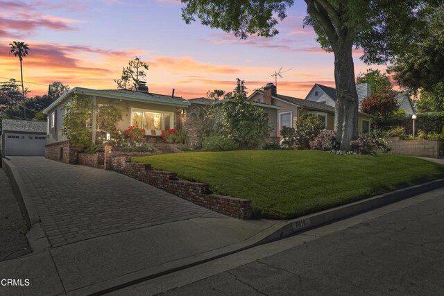 view of front of house featuring an outdoor structure, a garage, a front lawn, and driveway