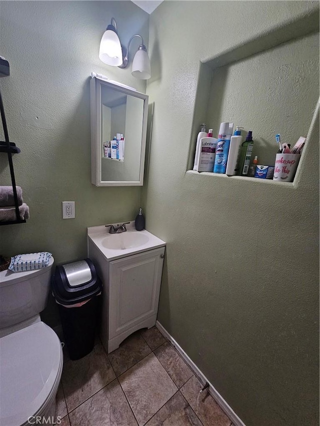 bathroom with tile patterned floors, toilet, vanity, and baseboards