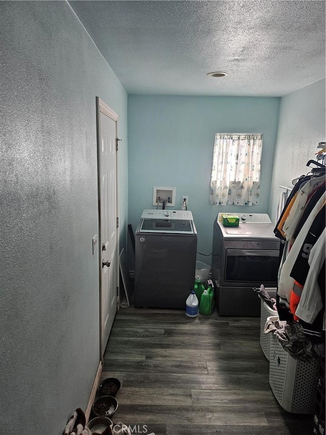 laundry area featuring washing machine and clothes dryer, wood finished floors, and a textured ceiling