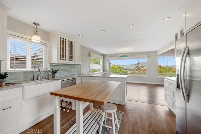 1264 Vista Del Osos, Los Osos, CA 93402 - kitchen with stainless steel appliances, a peninsula, a sink, dark wood-style floors, and glass insert cabinets