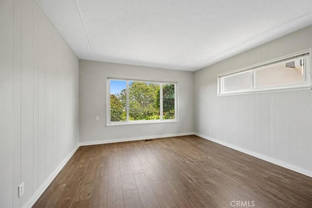 1264 Vista Del Osos, Los Osos, CA 93402 - empty room with dark wood-type flooring, baseboards, and wood walls