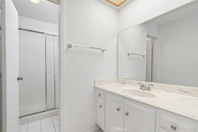 full bathroom featuring a shower stall, vanity, and tile patterned flooring