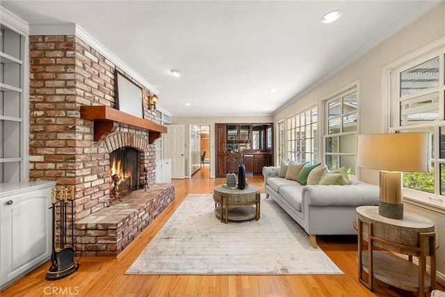 living area featuring a fireplace, wood finished floors, crown molding, and recessed lighting