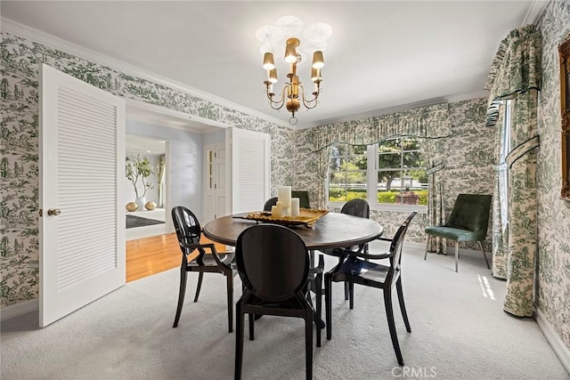 dining area featuring wallpapered walls, crown molding, a chandelier, light colored carpet, and baseboards
