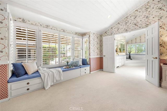 living area with wallpapered walls, vaulted ceiling, a wainscoted wall, carpet flooring, and ornamental molding