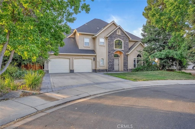 3894 Avocet Dr, Merced, CA 95340 - traditional home with stone siding, stucco siding, concrete driveway, an attached garage, and a front lawn