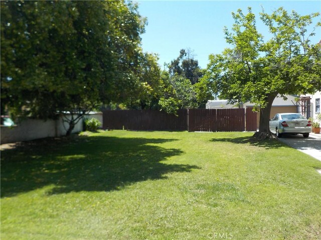 2698 Fremontia Dr, San Bernardino, CA 92404 - view of yard with concrete driveway and a garage